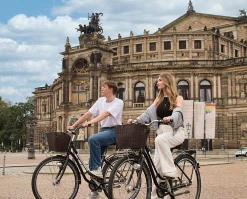 Junge Leute auf Leihfahrrädern vor der Semperoper