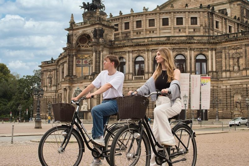 Junge Leute auf Leihfahrrädern vor der Semperoper