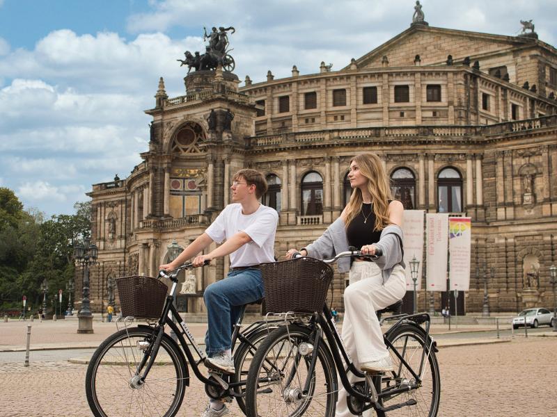 Junge Leute auf Leihfahrrädern vor der Semperoper