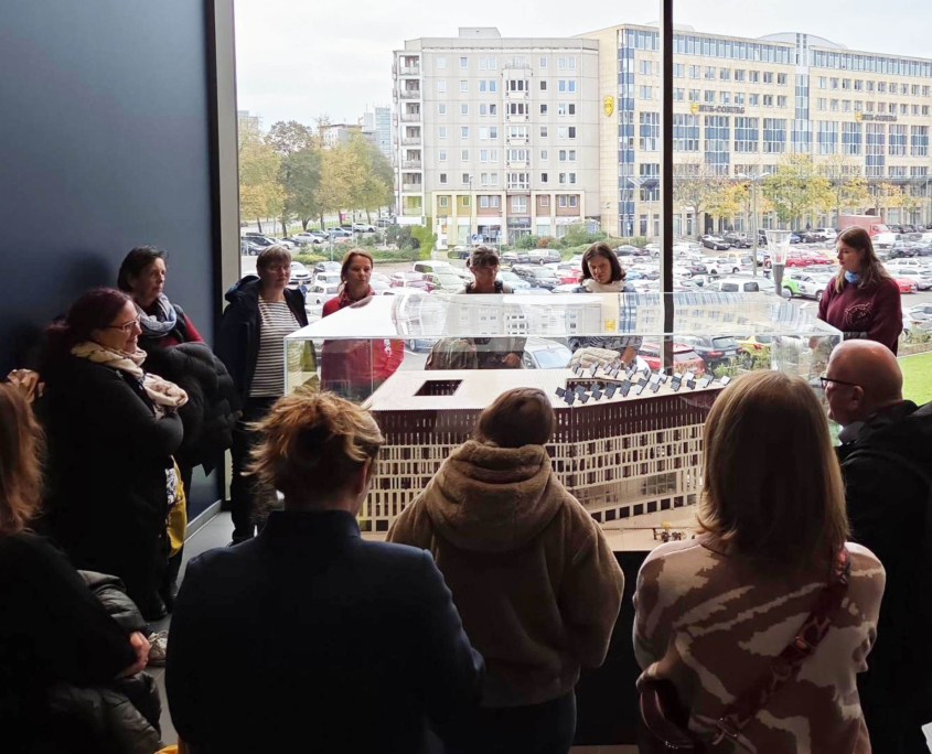 Eine Gruppe schaut auf ein Modell des Stadtforums Dresden