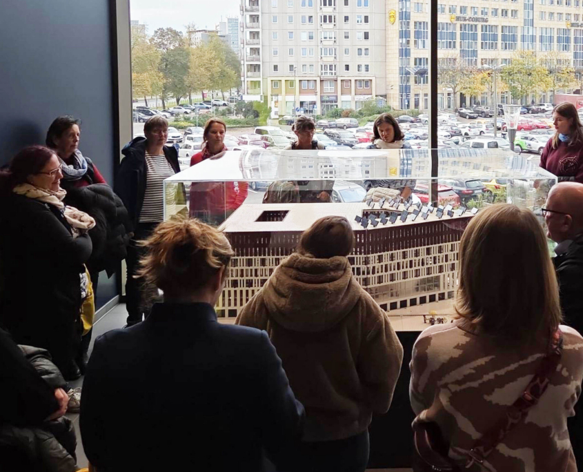 Eine Gruppe schaut auf ein Modell des Stadtforums Dresden